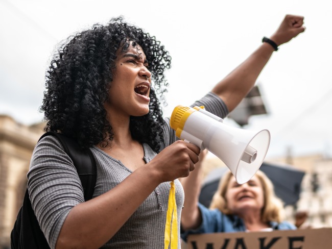 Young woman leading a demonstration using a megaphone