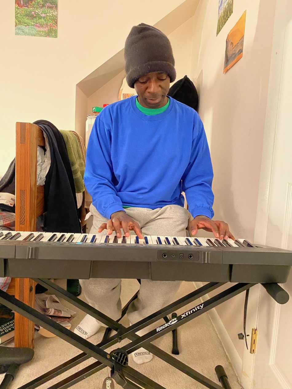 Photo of Mulumba Kazigo playing a keyboard